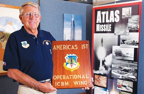 Jim Widlar, a former Atlas-D missile mechanic, posing with a plaque commemorating the part he played in Air Force history.